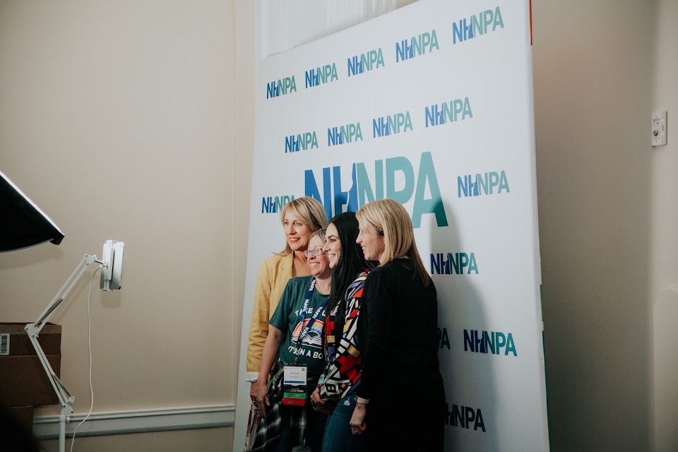 NHNPA members posing together at an event in front of the NHNPA step-and-repeat banner