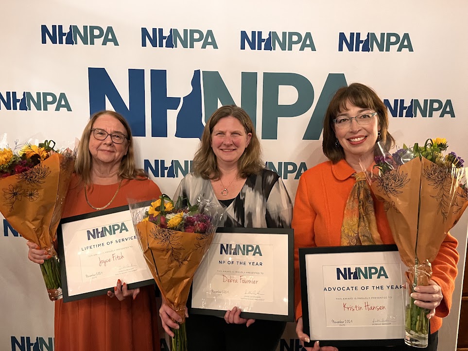 NHNPA award recipients Joyce Fitch, Debra Fournier, and Kristin Hansen holding framed awards and flowers in front of the NHNPA step-and-repeat banner
