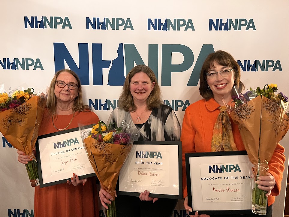 NHNPA award recipients Joyce Fitch, Debra Fournier, and Kristin Hansen holding framed awards and flowers in front of the NHNPA step-and-repeat banner