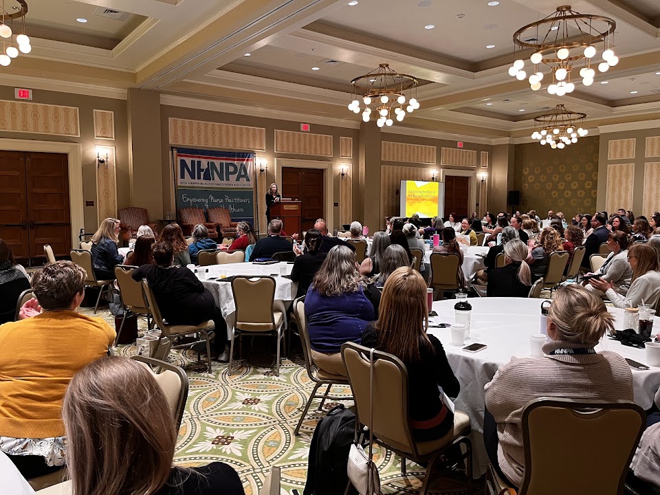 NHNPA conference session with attendees seated at round tables listening to a speaker at the New England Health Summit