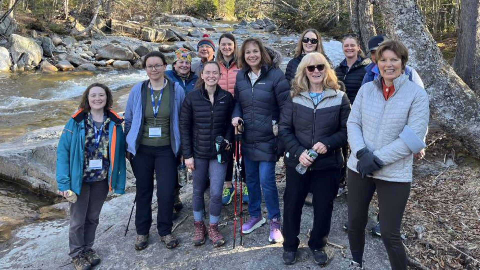 New England Health Summit attendees gathered beside a mountain stream.